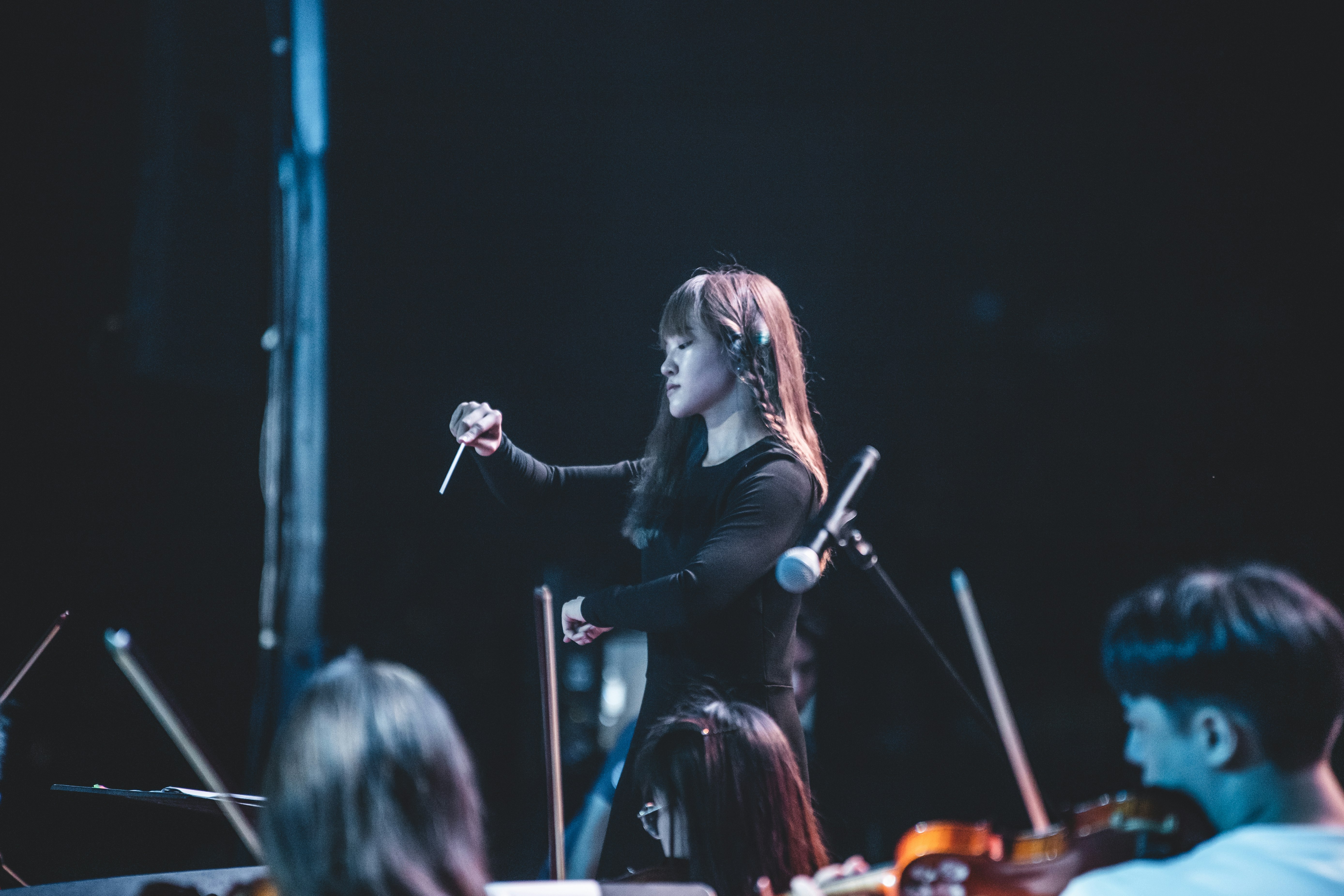 woman in black long sleeve shirt singing on stage